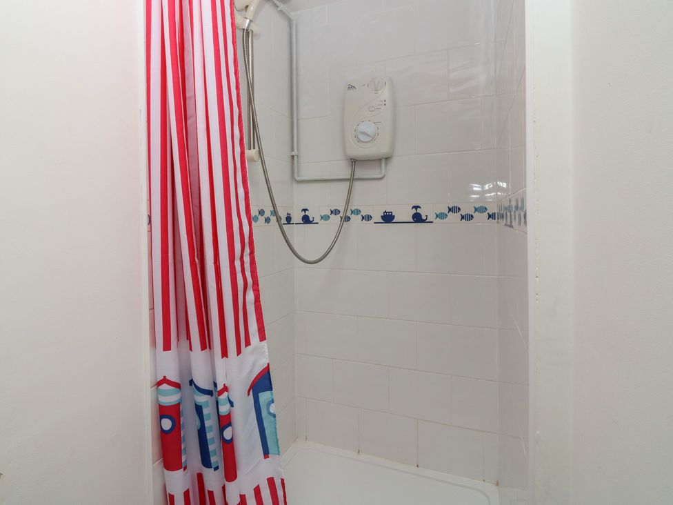 A shower with red and white striped curtain at Dookers' Hoose in Cullen