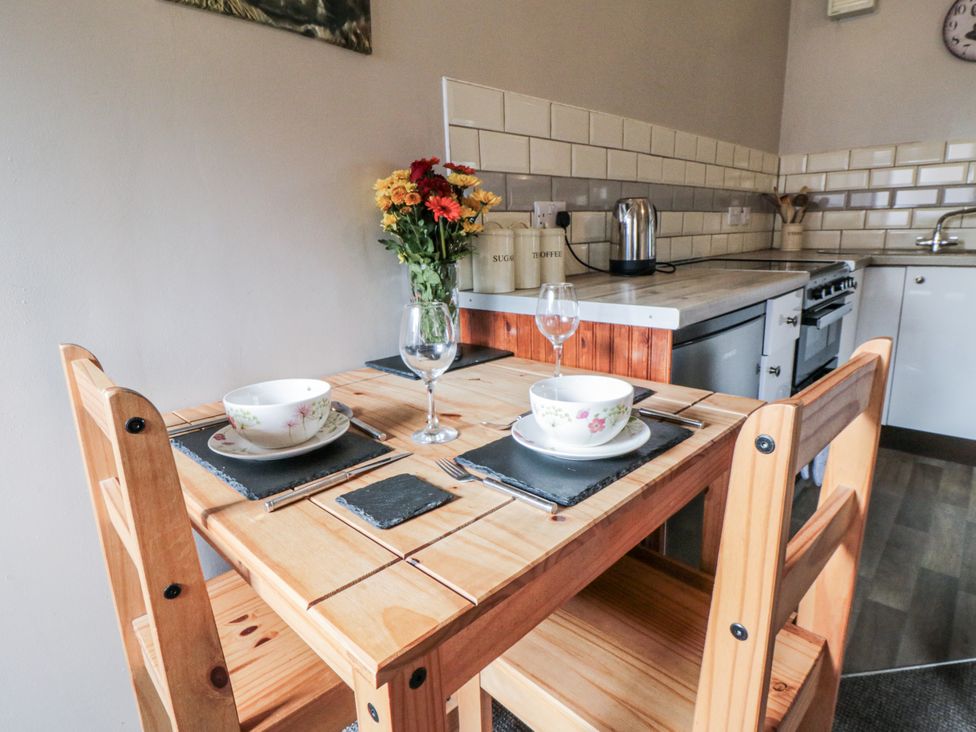 A kitchen with a wooden table and chairs at Carters in Staintondale