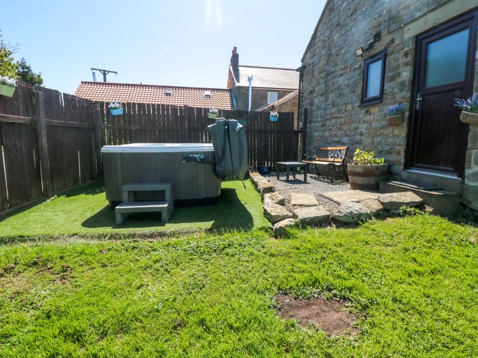 A garden with a hot tub and seating area at Carters in Staintondale near Burniston