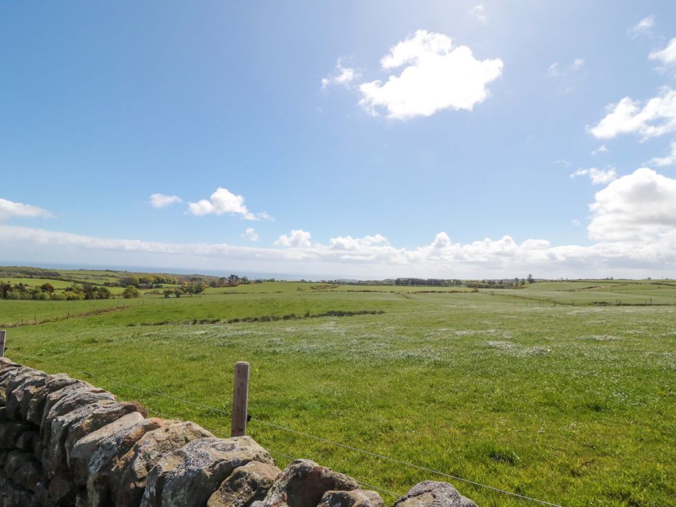 An open field with a stone wall and a clear sky at Carters in Staintondale near Burniston