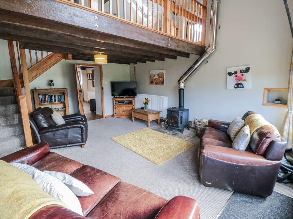 A living room with a sofa and a television at Hayloft in Staintondale