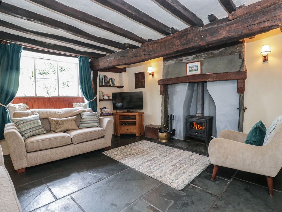 A living room with a sofa and wood burner at Rose Cottage Broughton-In-Furness