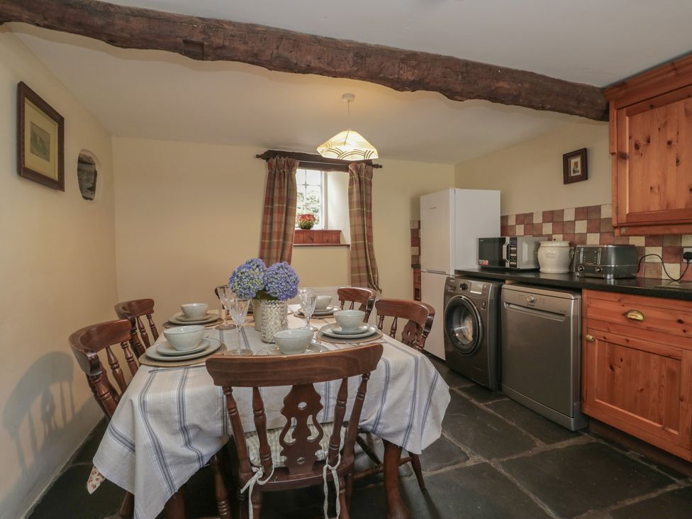 A kitchen with a dining table and appliances at Rose Cottage in Broughton-In-Furness