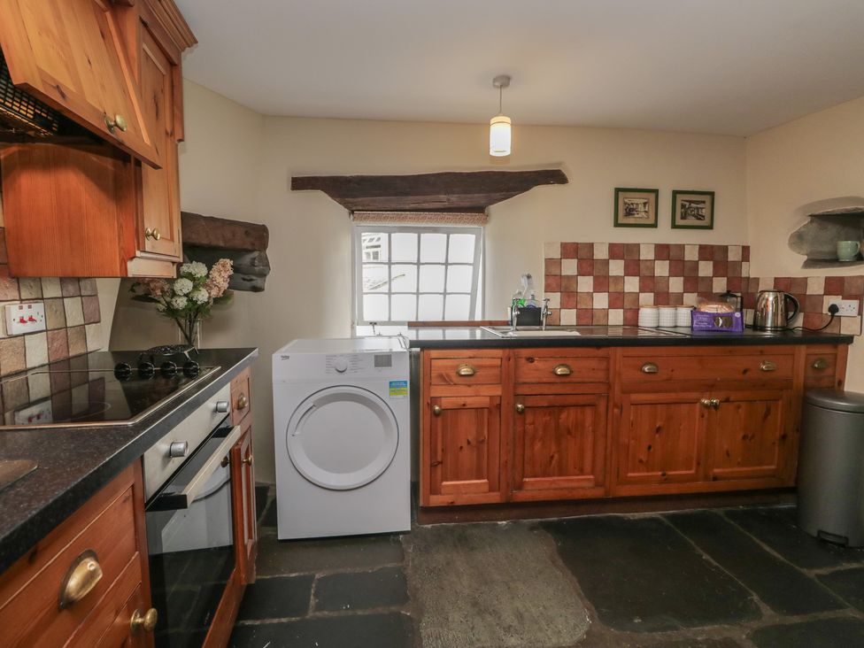 A kitchen with cabinets and appliances at Rose Cottage in Broughton-In-Furness