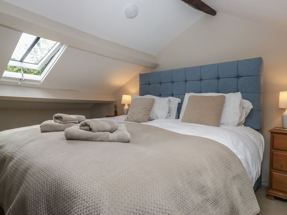 A bedroom with a bed and bedside lamp at Rose Cottage in Broughton-In-Furness