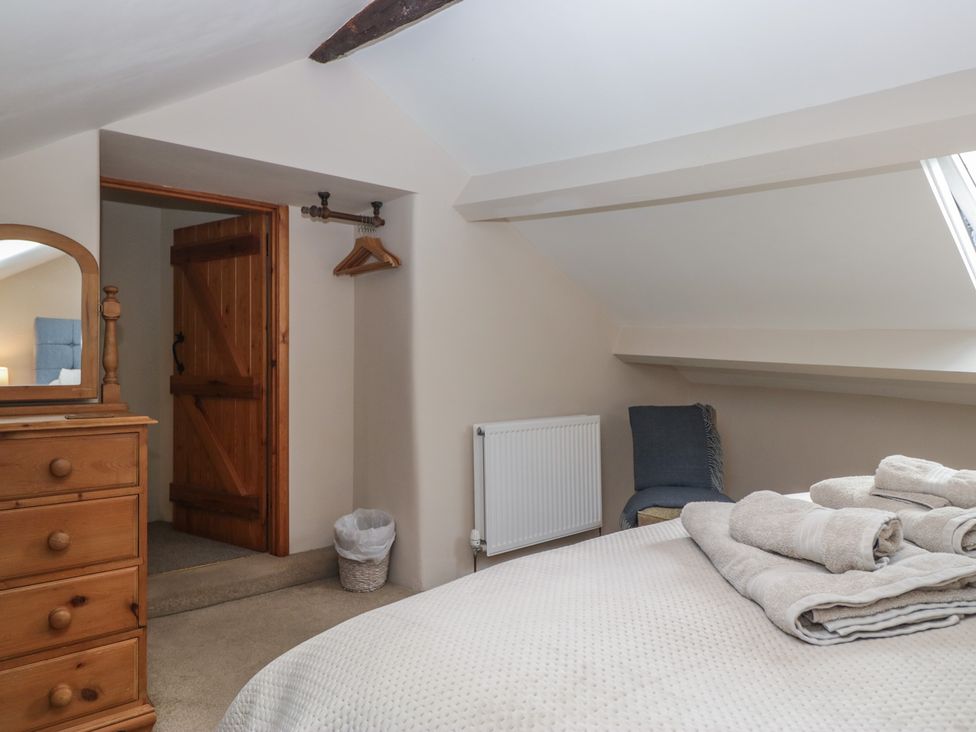 A bedroom with a bed and dresser at Rose Cottage in Broughton-In-Furness