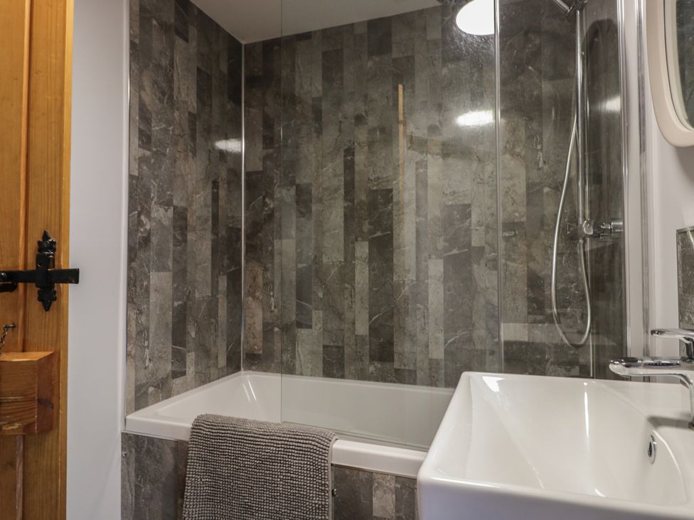 A bathroom with a bathtub and sink at Rose Cottage in Broughton-In-Furness
