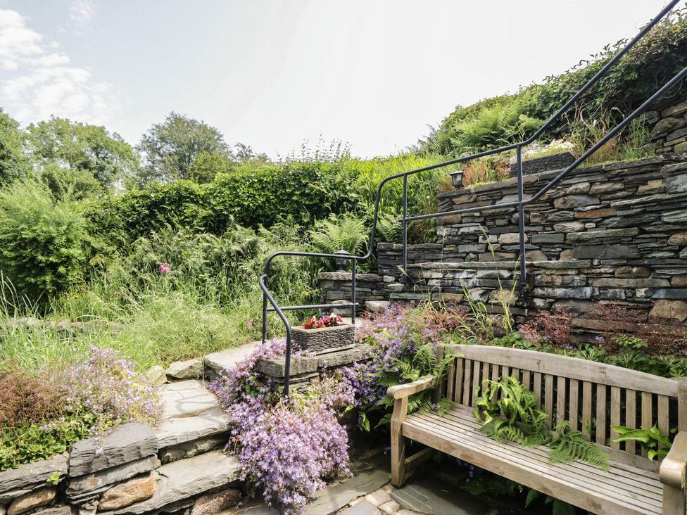 A garden with steps and a wooden bench at Rose Cottage in Broughton-In-Furness