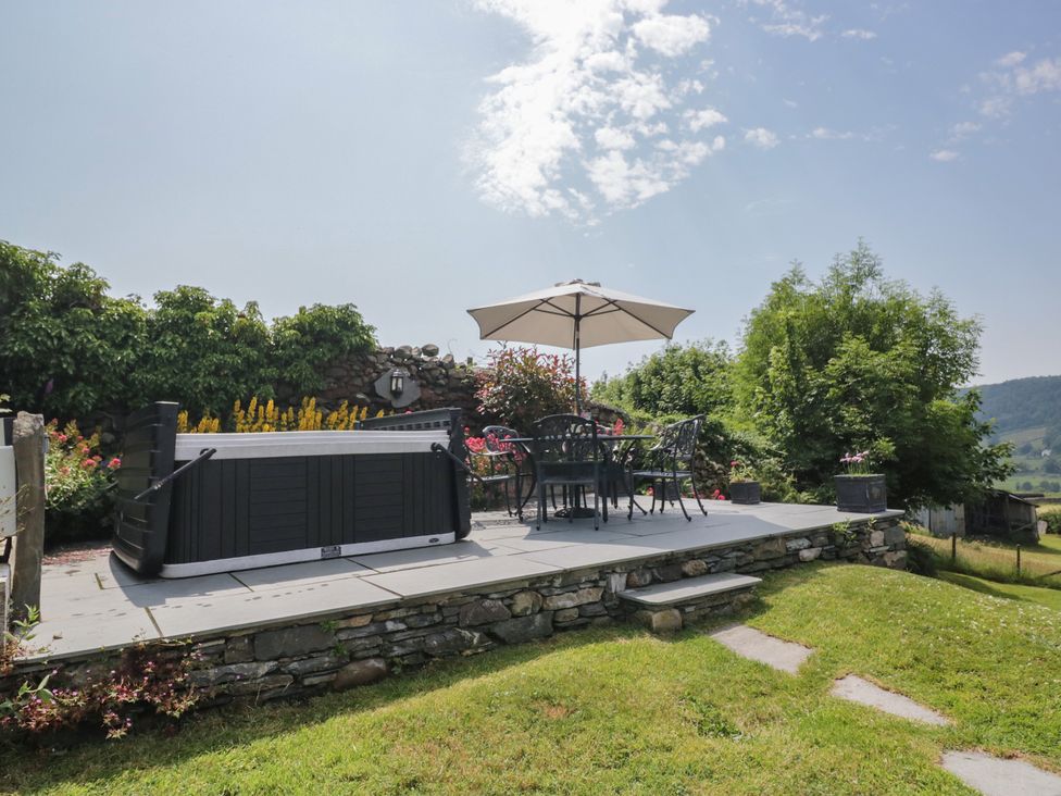 A garden with a hot tub and seating area at Rose Cottage in Broughton-In-Furness