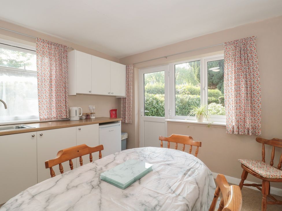 A kitchen with a table and chairs at 1 Westcroft Cottage in King's Stanley