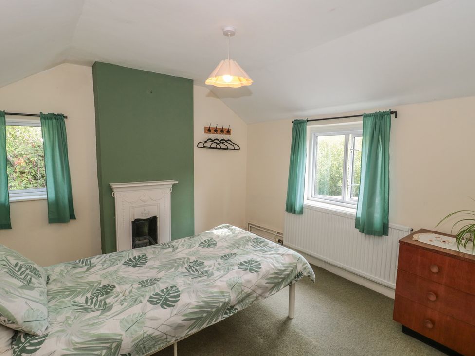 A bedroom with a bed and dresser at 1 Westcroft Cottage in King's Stanley