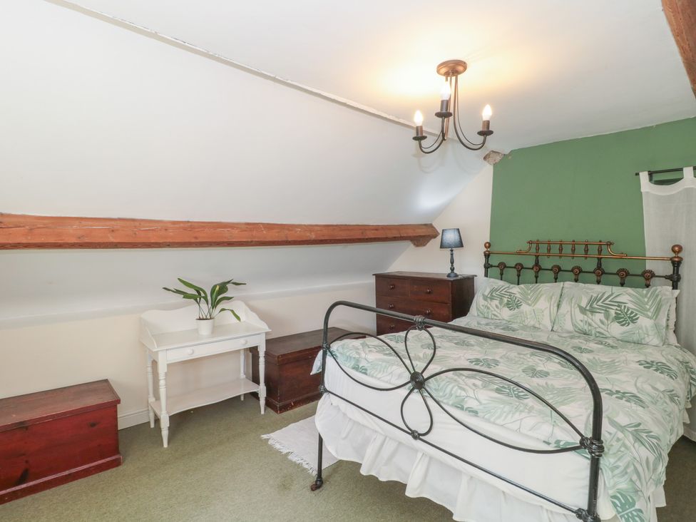 A bedroom with a bed and bedside table at 1 Westcroft Cottage, King's Stanley