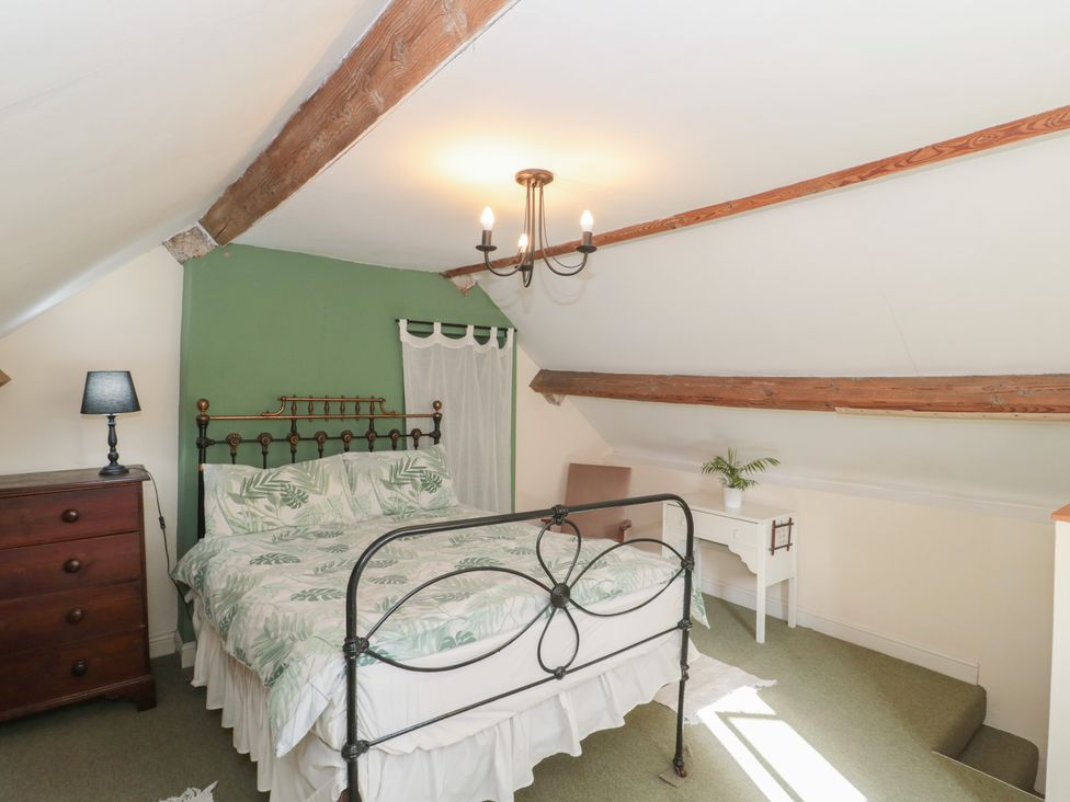 A bedroom with a bed and lampshade at 1 Westcroft Cottage in King's Stanley