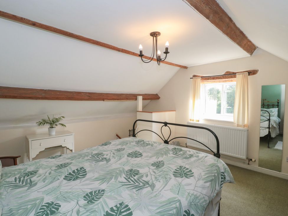 A bedroom with a bed and a plant at 1 Westcroft Cottage in King's Stanley