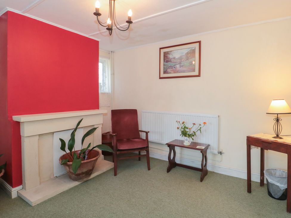 A living room with a chimney and armchair at 1 Westcroft Cottage in King's Stanley