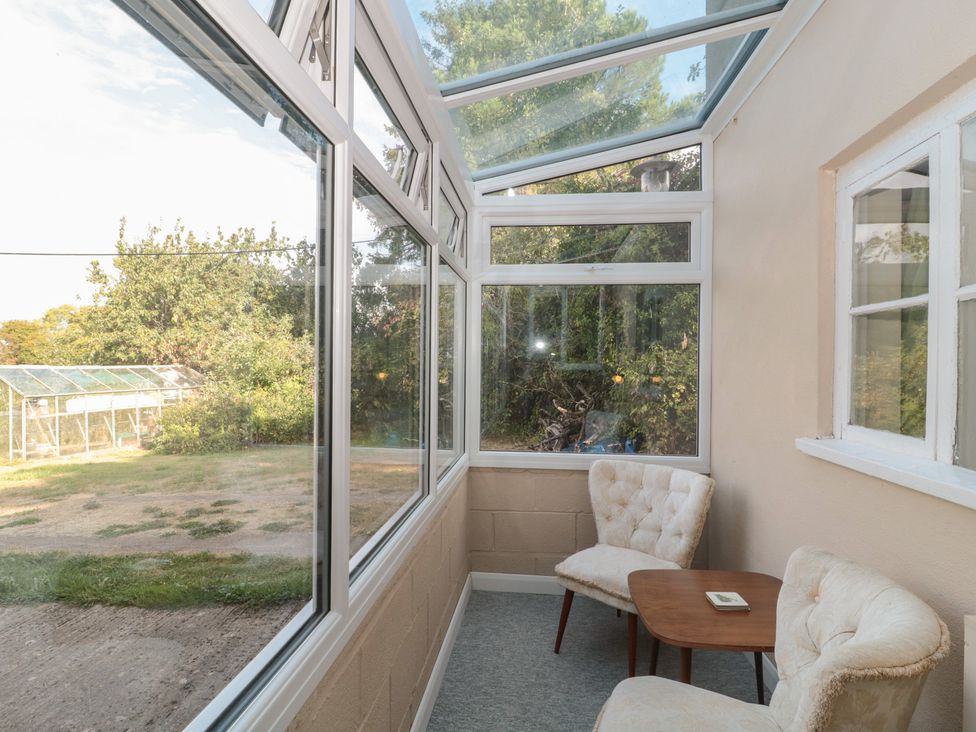 A conservatory with chairs and table at 1 Westcroft Cottage King's Stanley