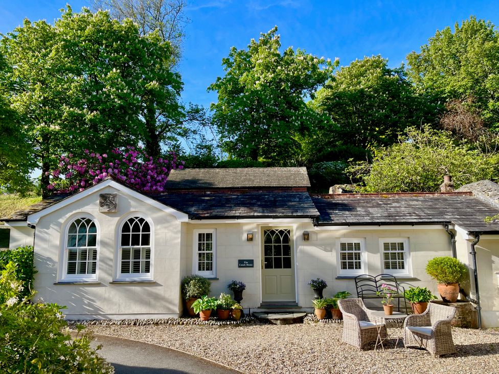 A house with a gravel pathway and chairs outside at The Coach House at Pendower House Fowey