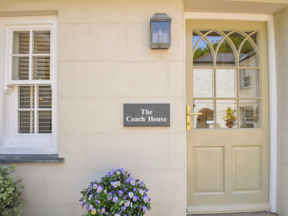 An entrance with a door and sign at The Coach House at Pendower House Fowey
