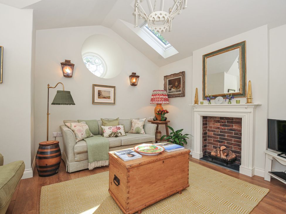 A living room with a sofa and coffee table at The Coach House at Pendower House in Fowey