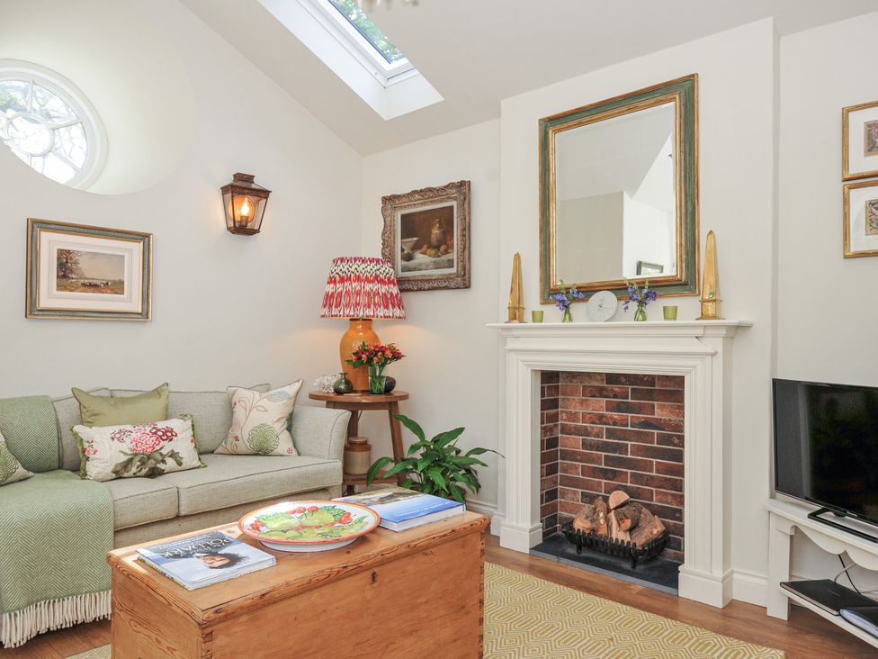 A living room with a sofa and decorative items at The Coach House at Pendower House Fowey