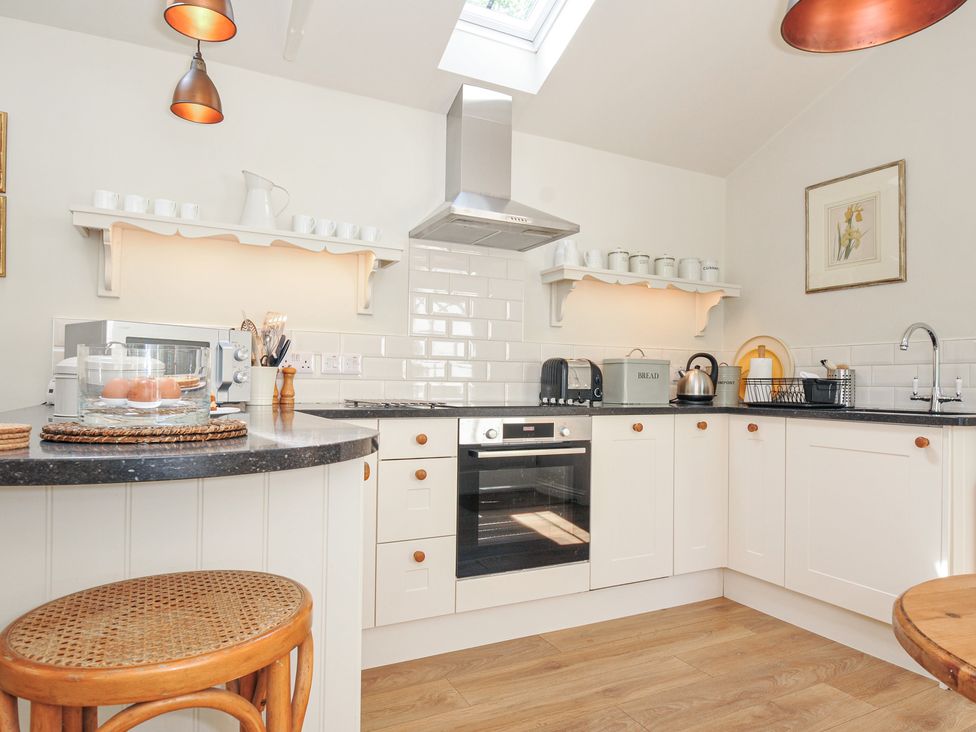 A kitchen equipped with appliances and shelving at The Coach House at Pendower House Fowey