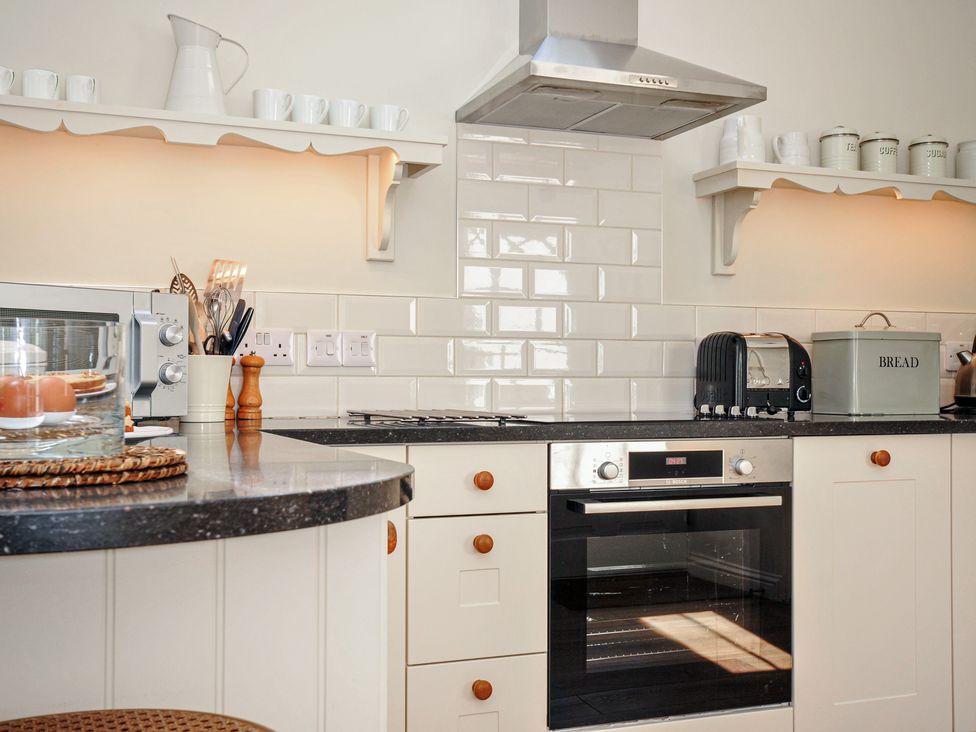A kitchen with an oven and microwave at The Coach House at Pendower House Fowey