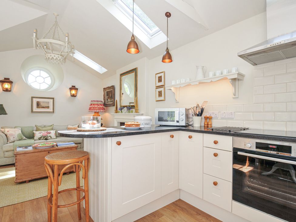 A kitchen with a counter oven and microwave at The Coach House at Pendower House, Fowey