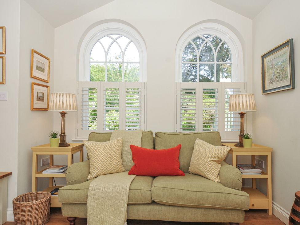 A living room with a sofa and lamps at The Coach House at Pendower House in Fowey