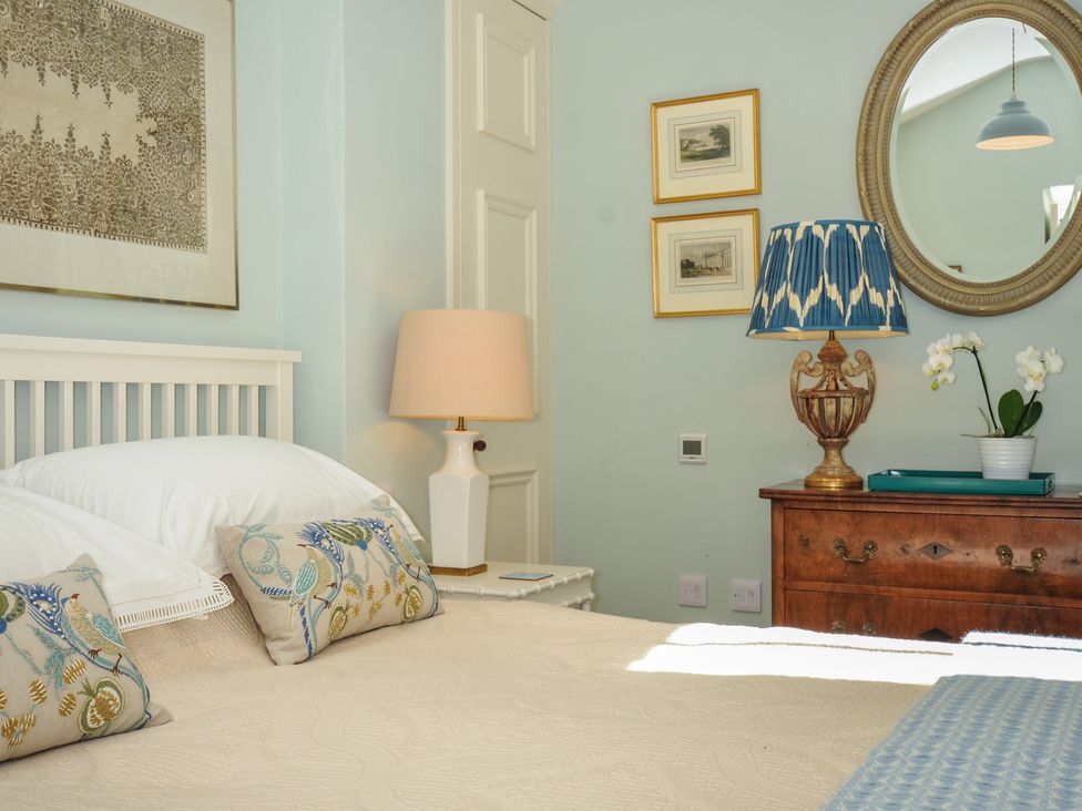 A bedroom with a bed and lamp at The Coach House at Pendower House, Fowey