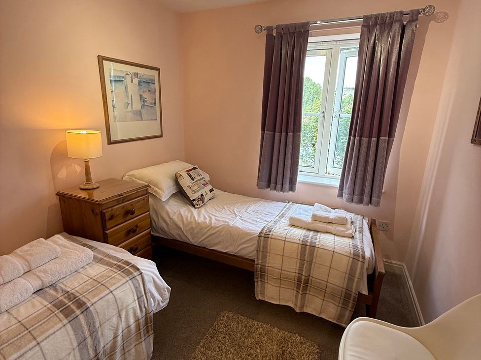 A bedroom with two beds and a window at Sandy Bottoms in Whitby