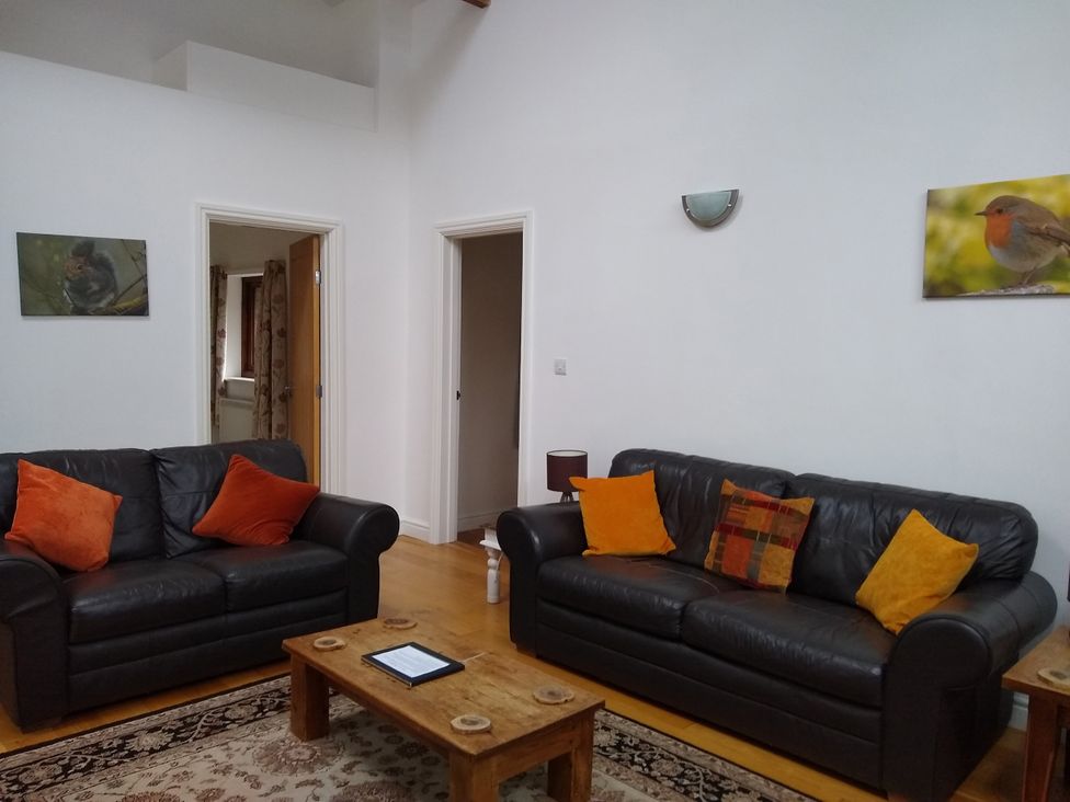 A living room with sofas and a coffee table at Dilly Dally Barn in Bradworthy near Bude