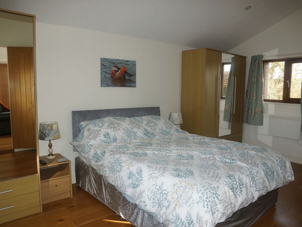 A bedroom with a bed and wardrobe at Dilly Dally Barn Bradworthy near Bude