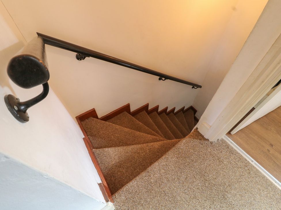 A staircase with a handrail and carpet at The Hill in Cromford