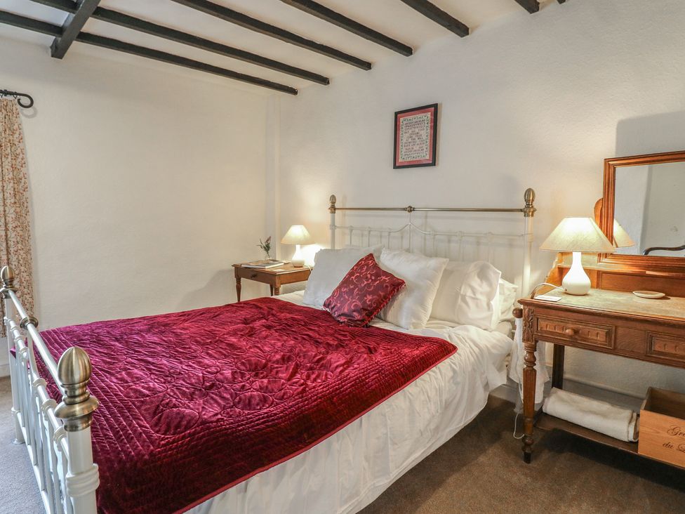 A bedroom with a bed and bedside table at The Hill in Cromford