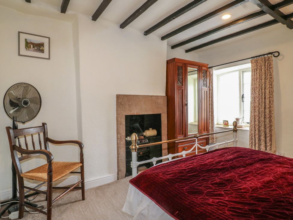 A bedroom with a bed and a fireplace at The Hill in Cromford
