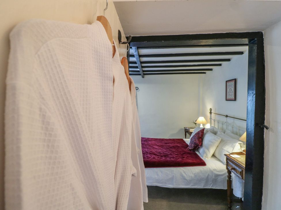 A bedroom with a bed and robes hanging at The Hill in Cromford