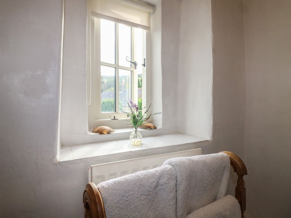 A sitting room with a window and a vase on a shelf at The Hill in Cromford