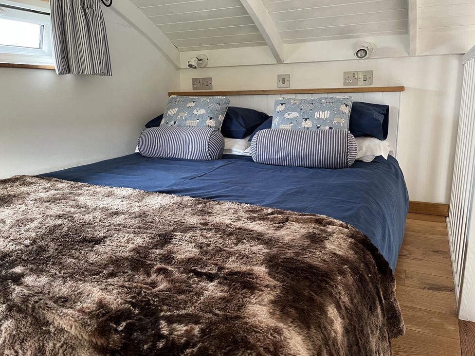 A bedroom with a bed and pillows at Shepherds Cabin at Titterstone Clee Hill