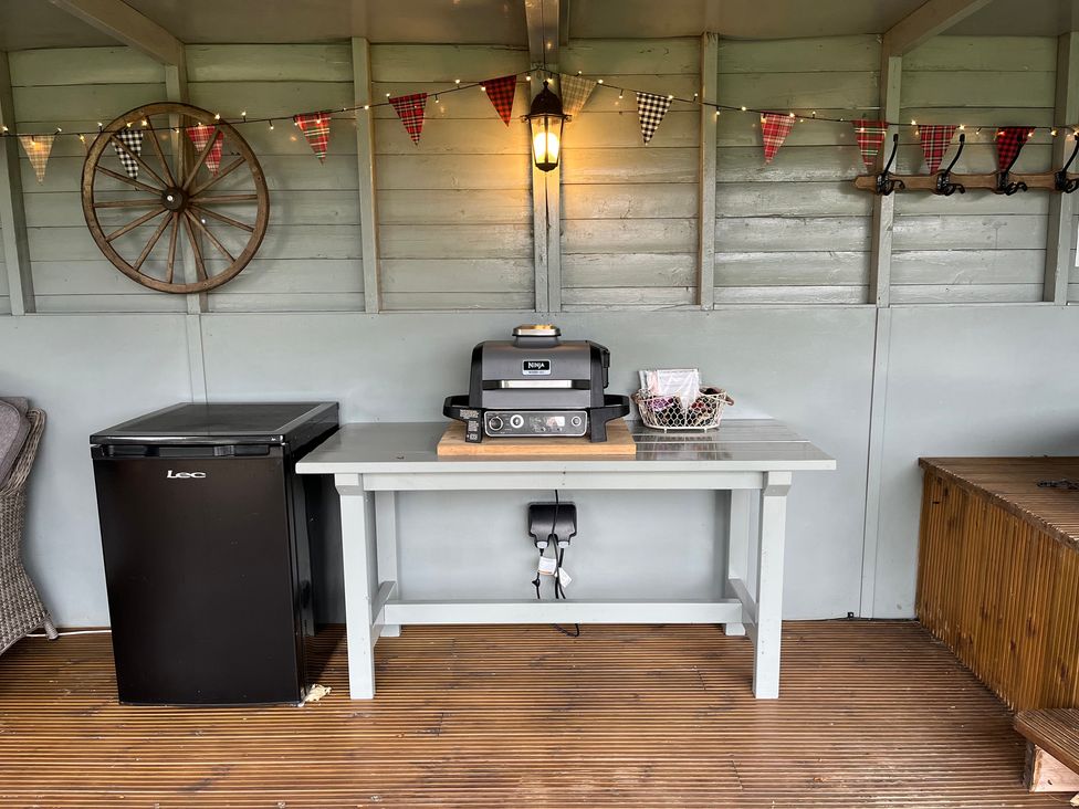 An outdoor shed with a grill and mini fridge at Shepherds Cabin at Titterstone Clee Hill