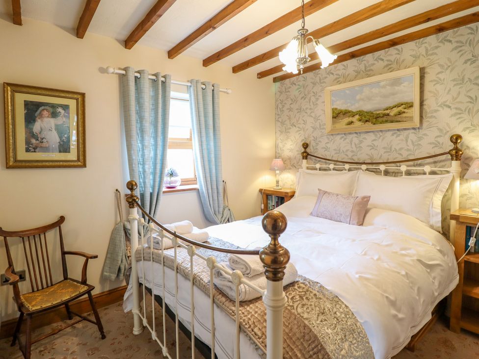 A bedroom with a bed and chair at Gelli Glud in Eglwysbach