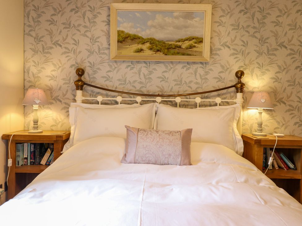 A bedroom with a bed and bedside tables at Gelli Glud in Eglwysbach