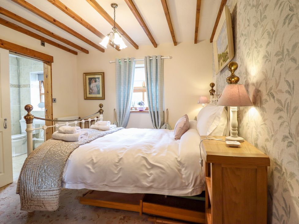 A bedroom with a bed and bedside table at Gelli Glud in Eglwysbach