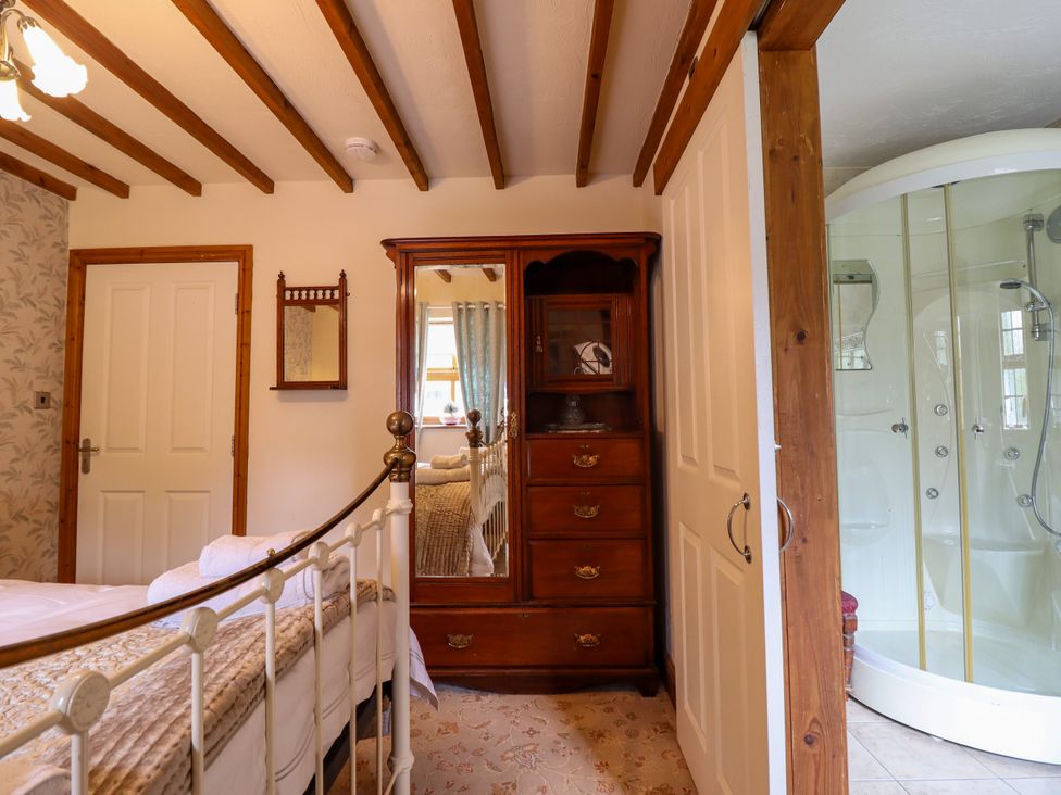 A bedroom with a bed and wardrobe at Gelli Glud Eglwysbach