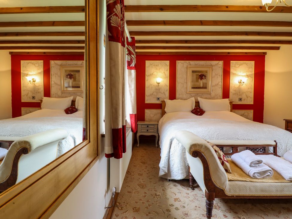 A bedroom with a bed and nightstand at Gelli Glud in Eglwysbach