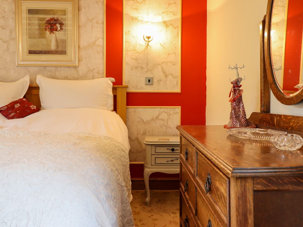 A bedroom with a bed and nightstand at Gelli Glud in Eglwysbach
