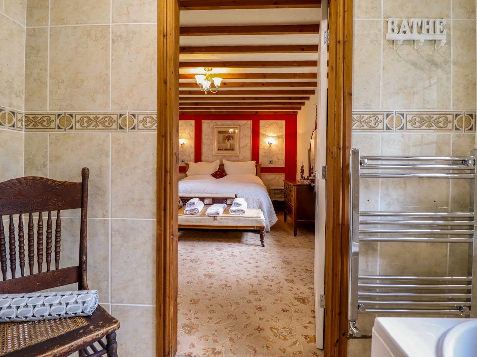 A bathroom with a view of a bedroom at Gelli Glud in Eglwysbach