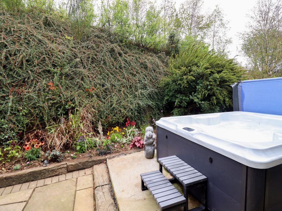 A garden with a hot tub and plants at Gelli Glud in Eglwysbach