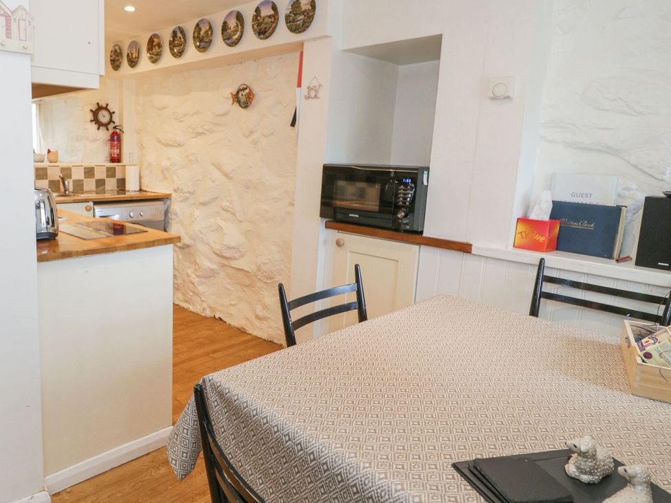 A kitchen with a table and chairs at Happy Landing in Llanfair