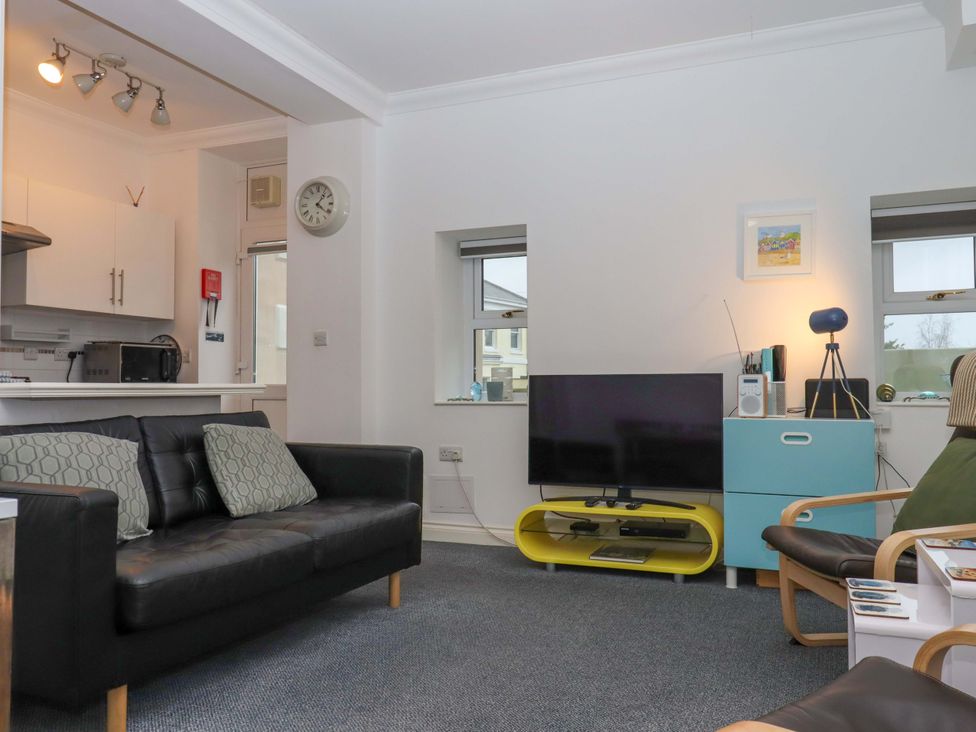 A living room with a sofa and television at Cottage 1 Newcourt Torquay
