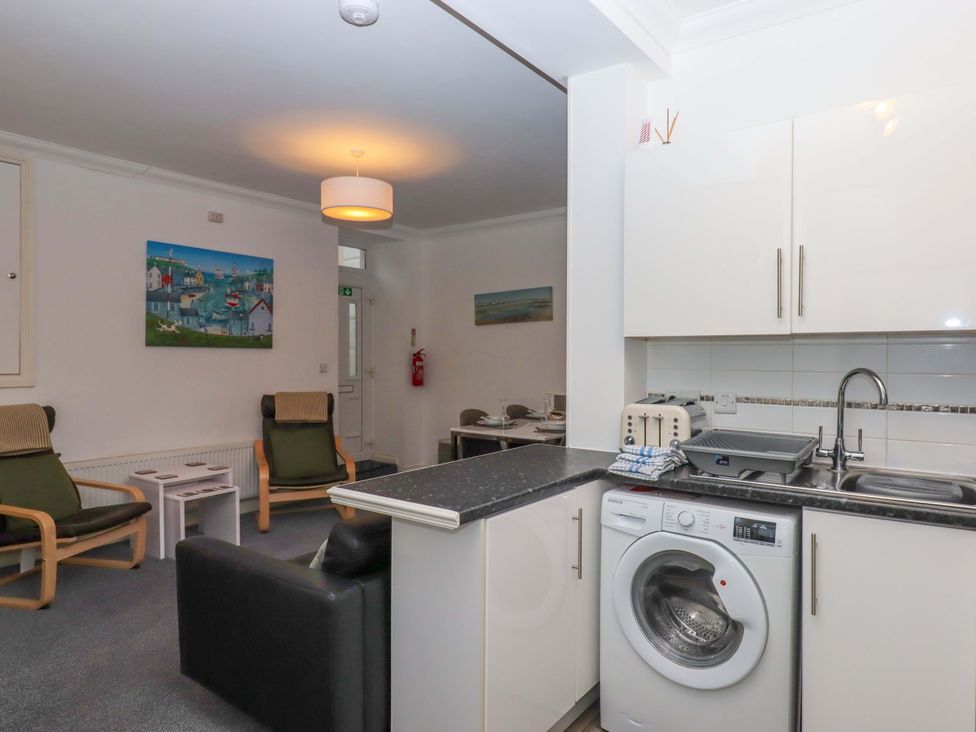 A living room with a washing machine and a toaster at Cottage 1 Newcourt in Torquay